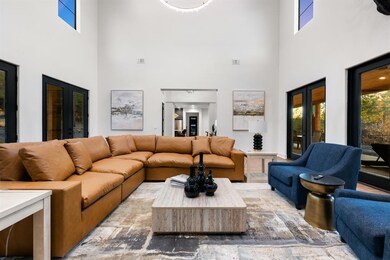 Living room featuring a high ceiling, plenty of natural light, and stone finish flooring