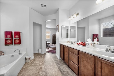 Bathroom with a bath, double vanity, a ceiling fan, and light tile patterned floors