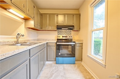 Kitchen with stainless steel electric stove, sink, and gray cabinets