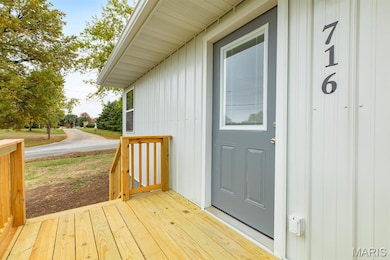 Entrance to property with board and batten siding and a deck