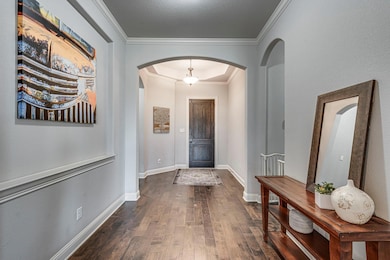 Foyer entrance featuring ornamental molding, arche