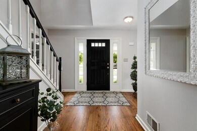 Welcoming entry with hardwood flooring and freshly
