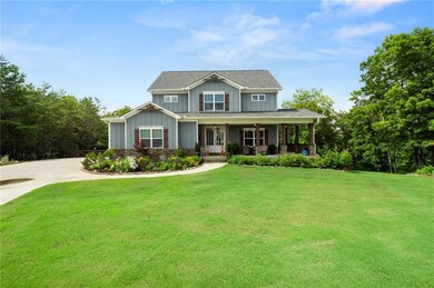 Craftsman-style home with board and batten siding, a front yard, a ceiling fan, and concrete driveway