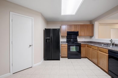 Kitchen featuring black appliances, range hood, l