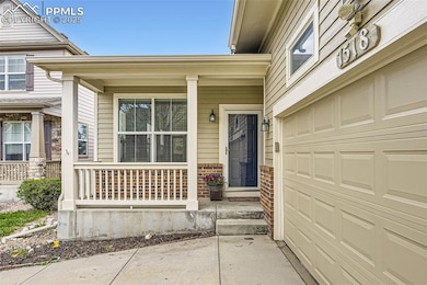 View of exterior entry with covered porch, a garage, and concrete driveway