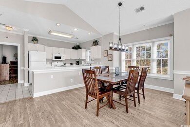 Dining room with light wood-style flooring, crown 