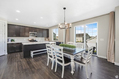 Dining room featuring a chandelier, dark wood finished floors, and recessed lighting