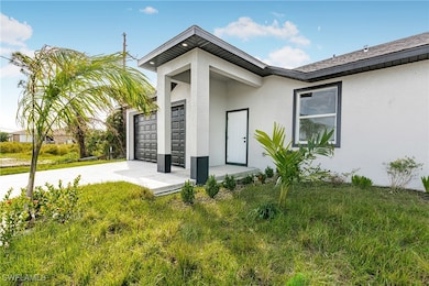 View of exterior entry with stucco siding, drivewa