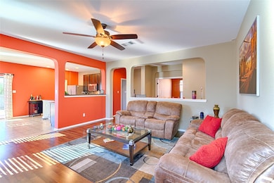 Living area with arched walkways, ceiling fan, an