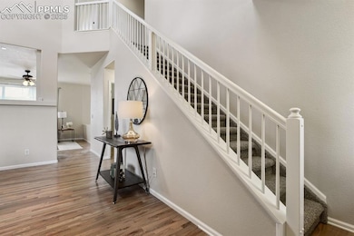 Stairway featuring wood finished floors, ceiling f