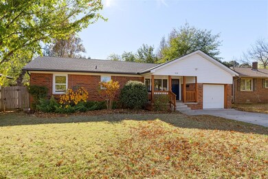Single story home featuring a front yard, a garage
