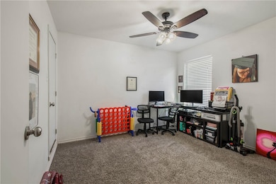 Office with carpet flooring and ceiling fan
