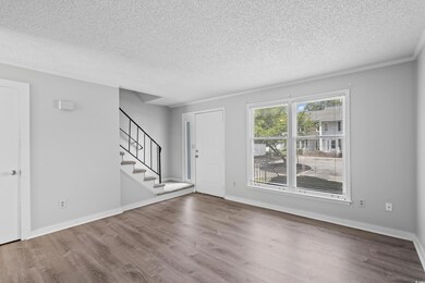 Entrance foyer featuring a textured ceiling, wood finished floors, stairway, and ornamental molding
