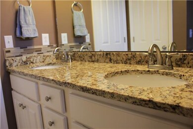 Double vanities in master bath with granite and un