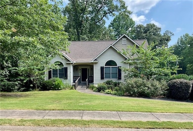 View of front of home featuring a shingled roof and a front yard