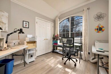 Office featuring lofted ceiling, laminate wood fin