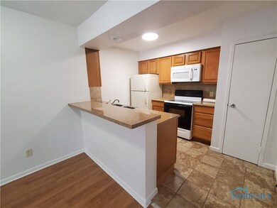 Kitchen has counter seating along with stove, refr