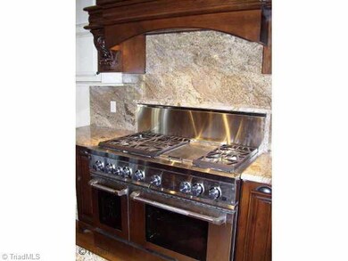 Kitchen. Enjoy meal prep using the commercial grade KitchenAid 6-burner gas stove with dual ovens.  Notice the beautiful Madikew Africian granite.  Hidden features include spice drawer and trash can pull-outs, custom pot-lid racking, cabinet-faced Bosch dishwasher