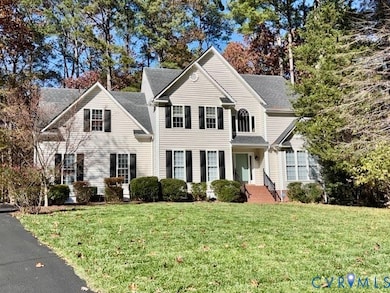 Traditional-style home with a front yard and a shingled roof