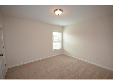 Empty room with light carpet and baseboards