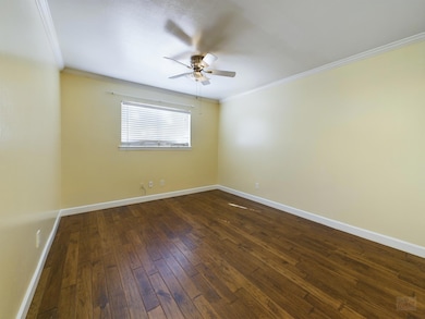 Empty room featuring ceiling fan, dark wood-style