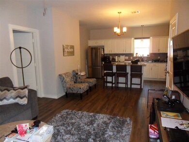 Living area with dark wood-style floors and a cha
