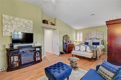 Bedroom with light wood-style floors, high vaulted ceiling, and a ceiling fan