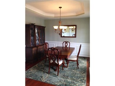 Dining room features hardwood floor, tray ceiling,