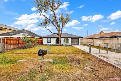 Ranch-style home with driveway, an attached garage, and a gate