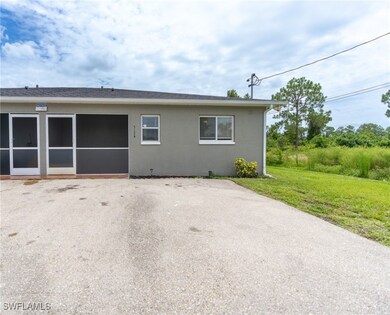 View of side of property with a lawn and stucco si