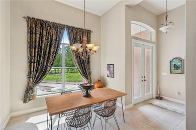 Dining area with french doors, a chandelier, and tile patterned floors
