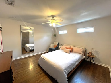 Bedroom with wood finished floors, baseboards, an