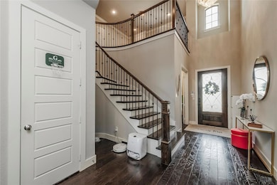 Foyer featuring wood-type flooring and a towering ceiling