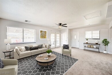 Carpeted living room with attic access, a textured ceiling, ceiling fan, and french doors