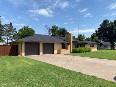 Ranch-style house with a garage, driveway, and a chimney