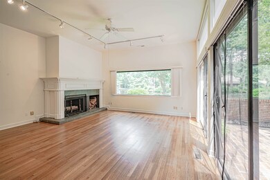 Unfurnished living room with track lighting, a ceiling fan, light wood-style floors, and a fireplace