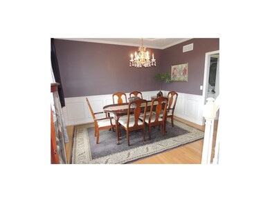 Formal dining room features hardwoods and wainscot