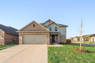 Craftsman inspired home with board and batten siding, brick siding, concrete driveway, a front lawn, and a garage
