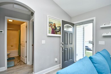 Foyer featuring vaulted ceiling and light hardwood