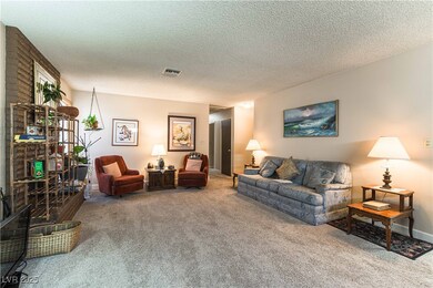 Living area with a textured ceiling, carpet floori