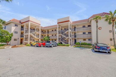 View of apartment building / complex featuring uncovered parking