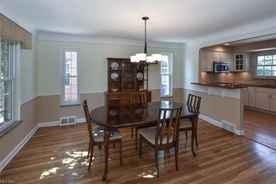 Hardwood floored dining room with sink and a chandelier