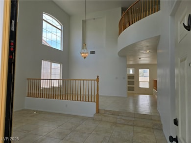 Unfurnished living room featuring a towering ceiling and a glass covered fireplace