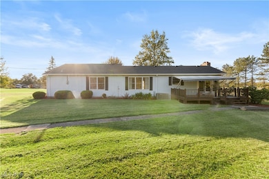 Ranch-style house with a deck, a front lawn, and a chimney