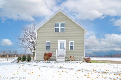 Snow covered back of property with entry steps