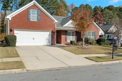 Traditional-style home featuring driveway, brick siding, a front yard, roof with shingles, and covered porch