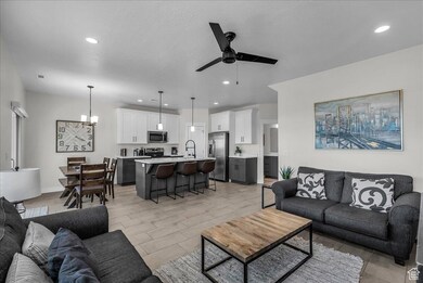 Living room with a chandelier, a ceiling fan, recessed lighting, and light wood-type flooring