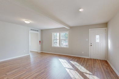 Foyer featuring beam ceiling and light wood-type f