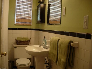 Original black/white tile bath, updated pedestal sink.