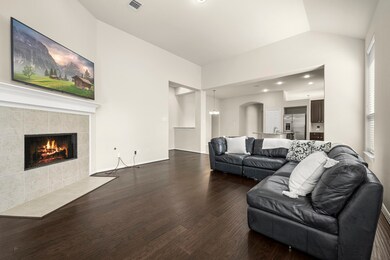 Welcoming fireplace with wood flooring and open to the kitchen and breakfast room.